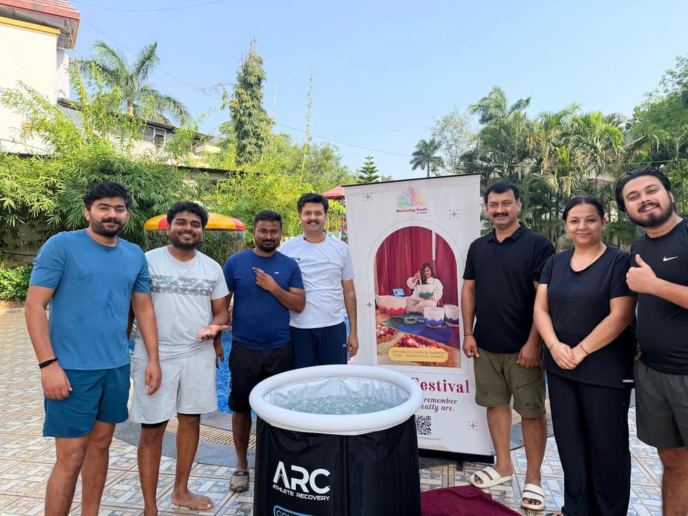 Participants gathered outdoors around an ice bath tub beneath palm trees before a cold immersion session